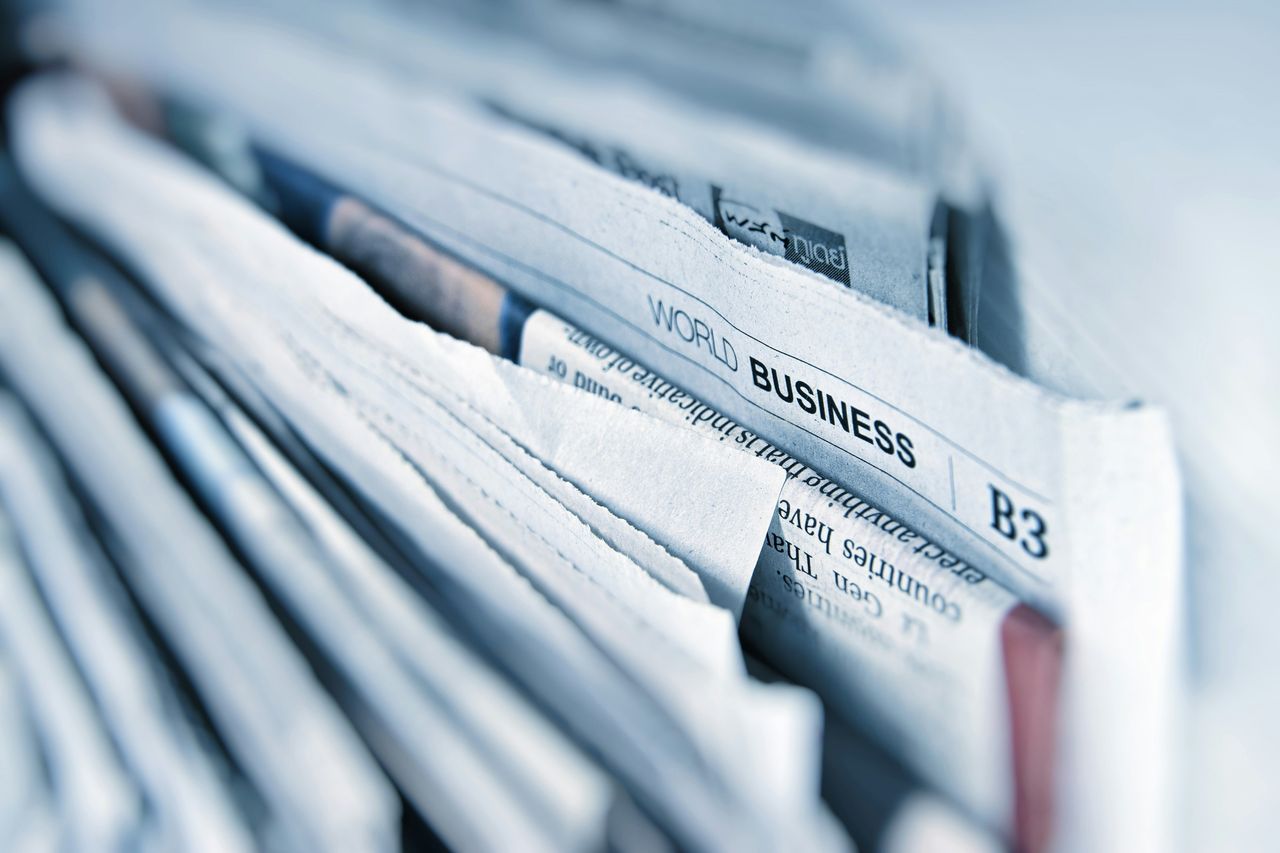 Stack of business newspapers and printed guides