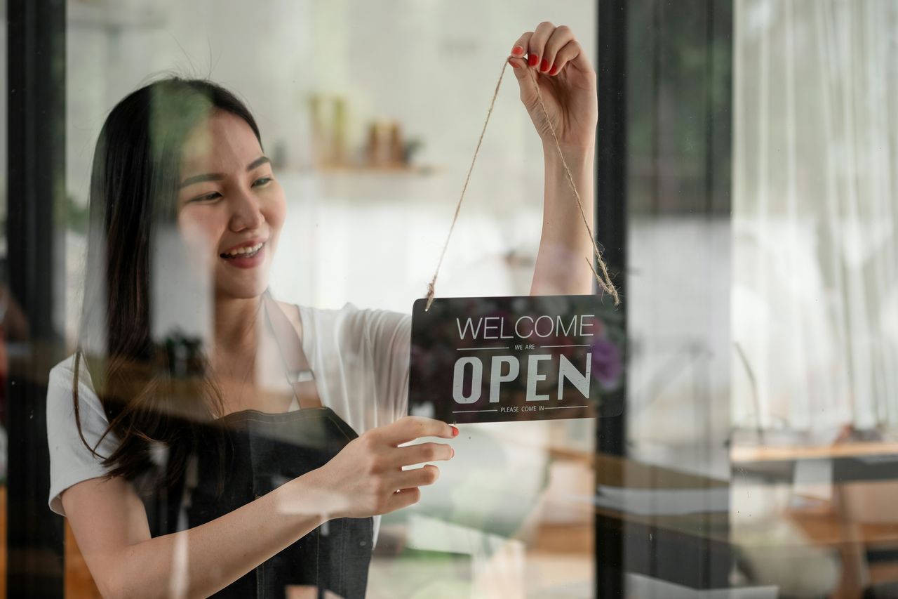 Shop owner turning the store sign to open