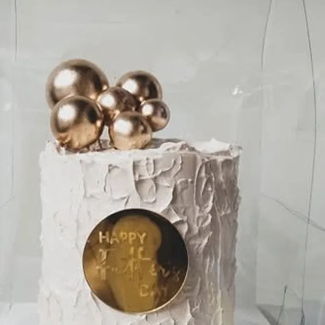 Gold spheres on a textured buttercream cake